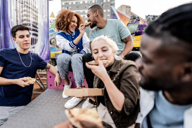 istock Friends talking and eating pizza at the amusement park 1683171866