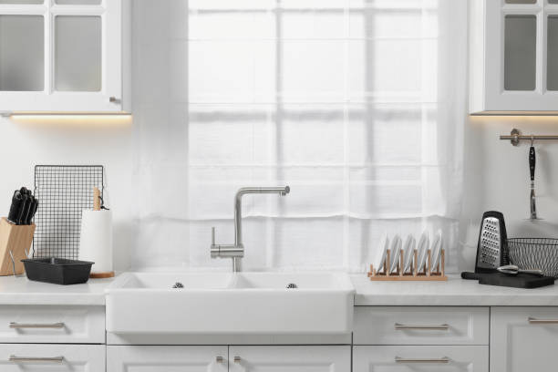 istock Set of different utensils near sink on countertop in kitchen 1683172408