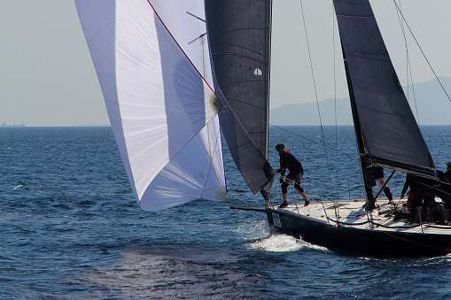 International laser class sailing boat with young male boats-man practicing, close-up