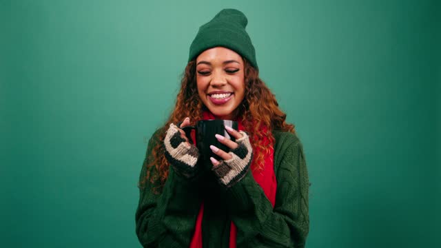 Beautiful young woman smiles and holds warm drink, Christmas cozy theme studio