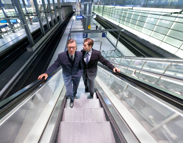 istock businessmen standing on escalator in modern railway station 168318449
