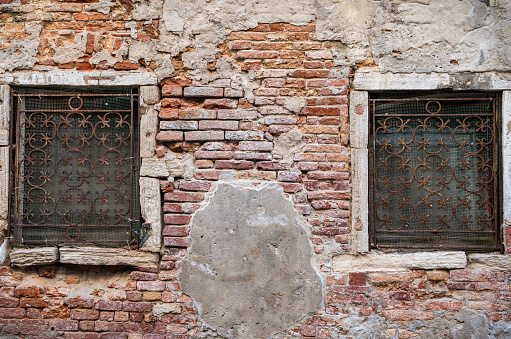 Old medieval worn out brick wall building in Venice, Italy.