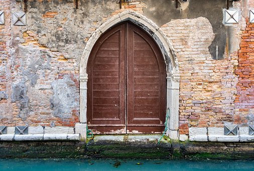 Close up detail with old medieval building architecture venetian entrance door.