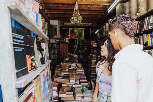 Young couple choosing a book to buy at book store