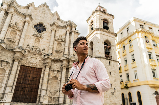 Traveler young photographer man admiration Havana Cathedral, Cuba