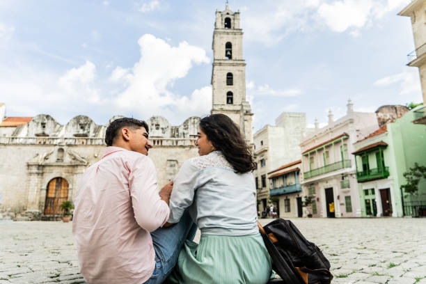 istock Young couple talking sitting on ground outdoors 1683192880