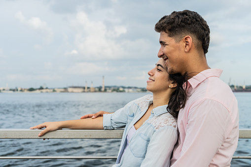 Young couple looking at view relaxing on a pier