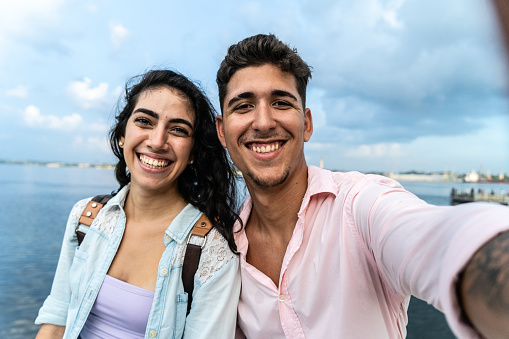 Couple traveler taking a selfie outdoors - Camera point of view
