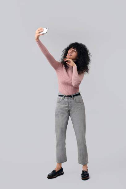istock Beautiful young woman taking selfie on light grey background 1683217977