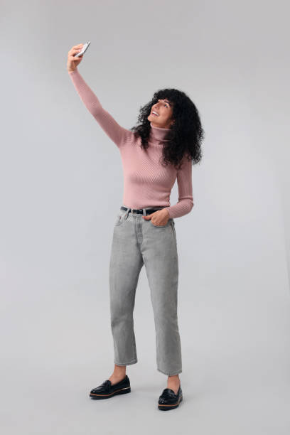 istock Beautiful young woman taking selfie on light grey background 1683218146