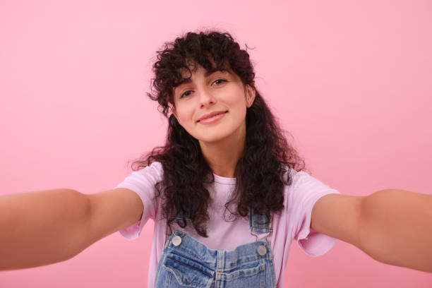 istock Beautiful woman taking selfie on pink background 1683219259