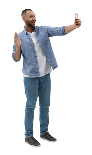 istock Smiling young man taking selfie with smartphone on white background 1683236757