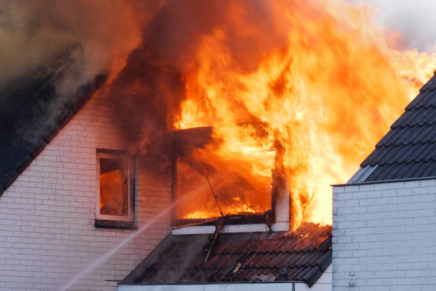 istock Flames coming out of white brick wall house on fire 168324196