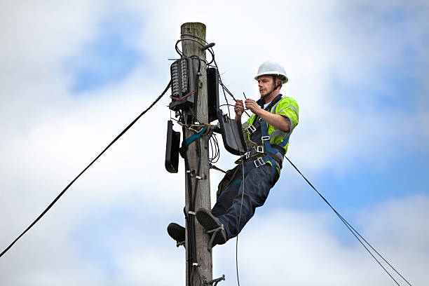 Telephone Engineer series Mid adult man working at the top of a telegraph pole steel cable photos stock pictures, royalty-free photos & images