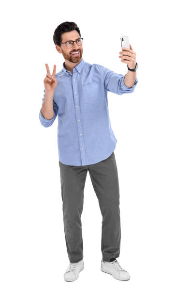 istock Smiling man taking selfie with smartphone and showing peace sign on white background 1683246003