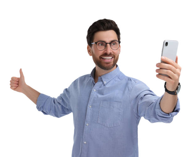 istock Smiling man taking selfie with smartphone and showing thumbs up on white background 1683246519