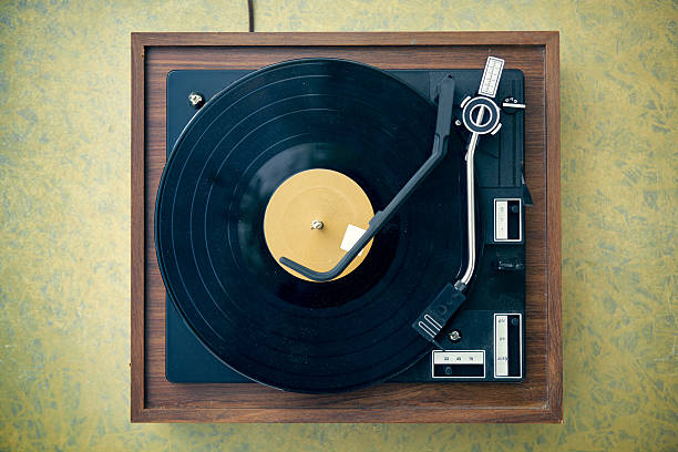 Dirty Turntable and Record on Formica Background A dusty, dirty, vintage wood and plastic record player from high angle view (directly above)), with retro formica 1960's table. Copy space on table and record; horizontal vintage turn table stock pictures, royalty-free photos & images