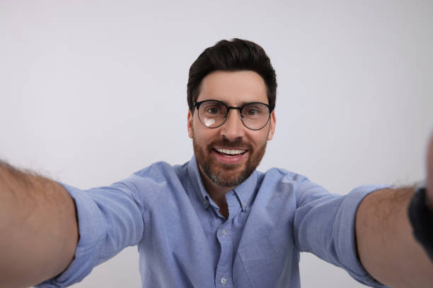istock Smiling man taking selfie on white background 1683249160