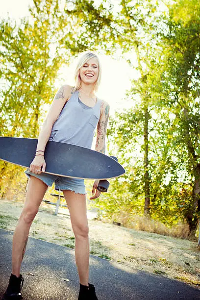 Photo of Attractive Young Woman with Longboard