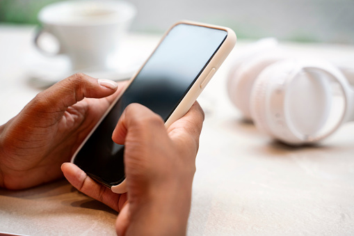 Closeup of business woman hands using mobile app shopping online, sending text message, selective focus. Female holding smartphone. Technology concept