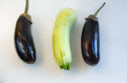 Black purple eggplants and  marrow summer squash vegetables  on the table. Autumn grocery shopping.