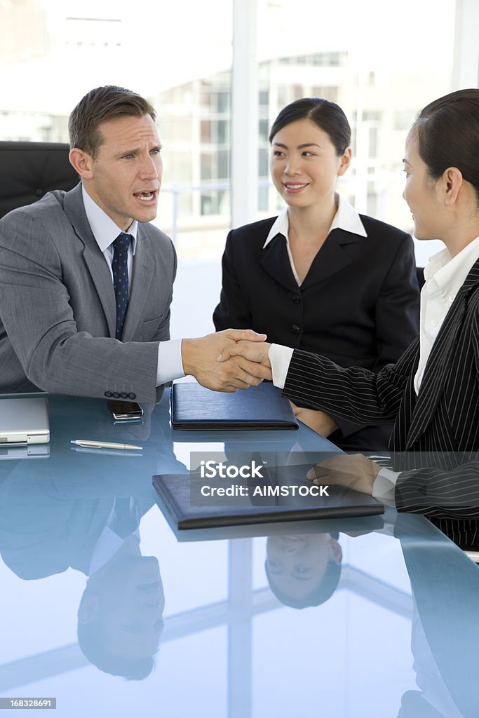 Business Deal with Asian people Business Handshake between Caucasian businessman and Chinese businesswoman. Translator in the middle. Sales Occupation Stock Photo
