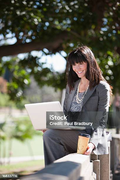 Foto de Mulher De Negócios Trabalhando No Laptop No Parque e mais fotos de stock de Laptop - Laptop, 25-30 Anos, A caminho