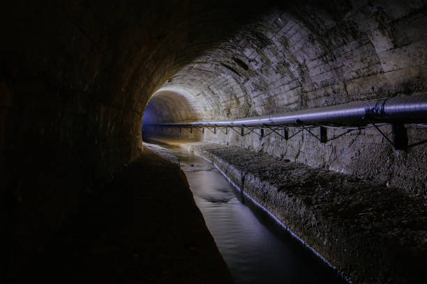 istock Underground vaulted urban sewer tunnel with dirty sewage 1683396335