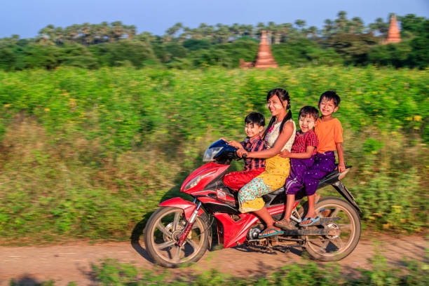 bambini birmani in moto, bagan, myanmar - bagan myanmar burmese culture family foto e immagini stock