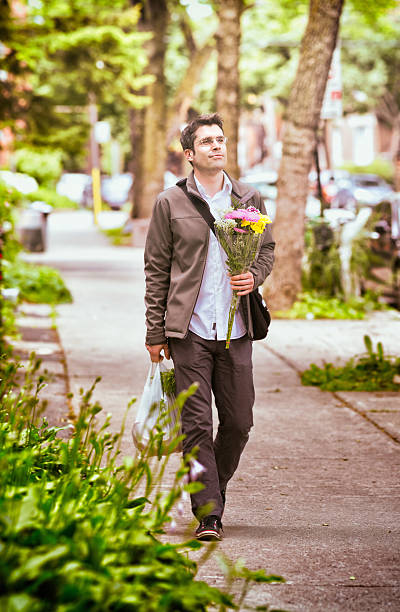 istock Romantic man walking home with flowers and groceries 168342537