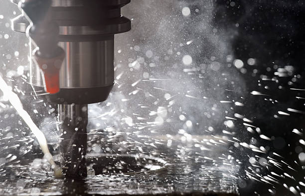 istock Back-lit CNC milling machine in operation cutting steel 168342615