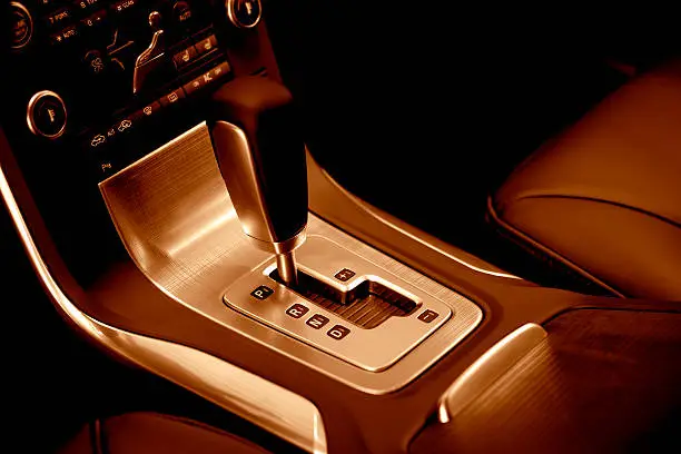 Photo of modern car automatic gearshift, red toned image