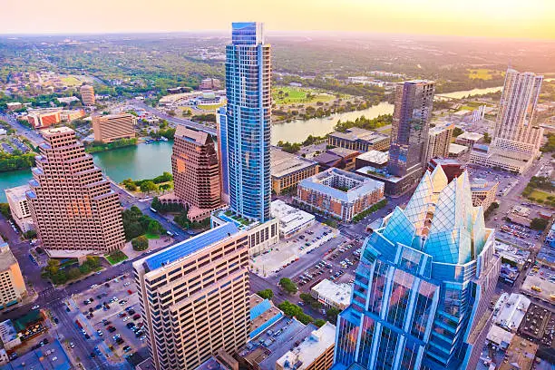 Austin Texas skyscrapers at sunset from helicopter. Frost Bank building in foreground. Austonian is tallest building.