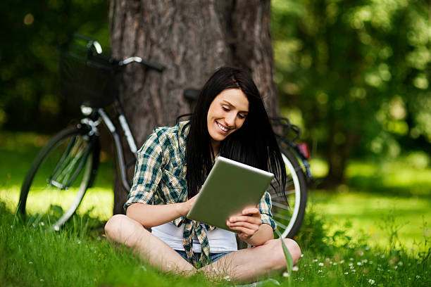 istock Beautiful young woman using digital tablet outdoors 168345026