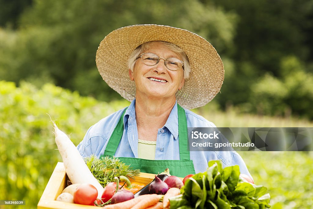 Femme âgée tenant la boîte en bois avec des légumes - Photo de Bonheur libre de droits