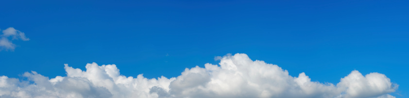 There is a large, cumulus cloud in the blue sky. Close-up