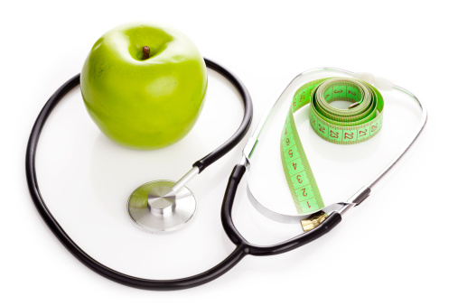 Apple ,measuring tape and stethoscope isolated on white