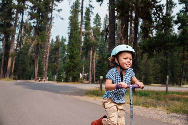 istock Cute little girl riding a scooter through a campground 1683551950