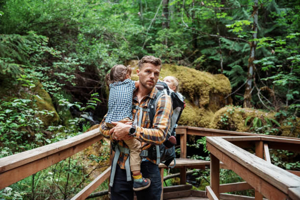 istock Active father with two kids hiking in the forest 1683553516