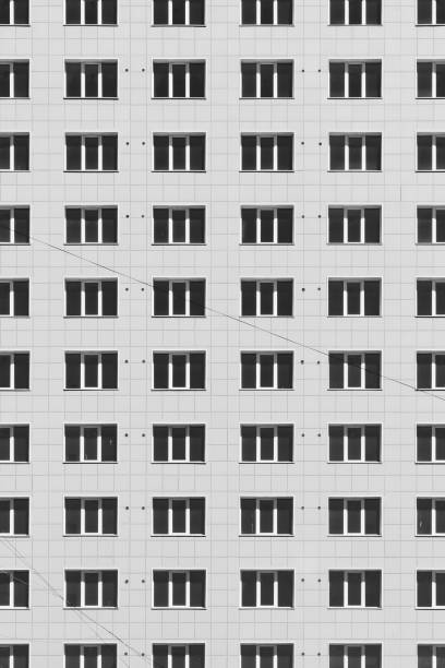 geometrischer hintergrund mit vielen fensterreihen. einfaches hochhaus in klassischem design. realistisches konzept des bürogebäudes. hintergrund, textur des mehrfamilienhauses. viele fenster an großen wänden in nahaufnahme. - architecture classic close up office building stock-fotos und bilder