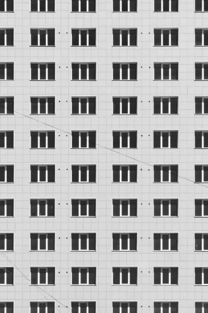 istock Geometric backdrop with lots of window rows. Simple classic design high-rise building. Realistic concept of office building. Apartment house texture background. Many windows on big wall close-up. 1683576892