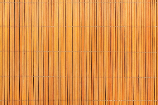 Top view of beige bamboo food placemat as background texture.