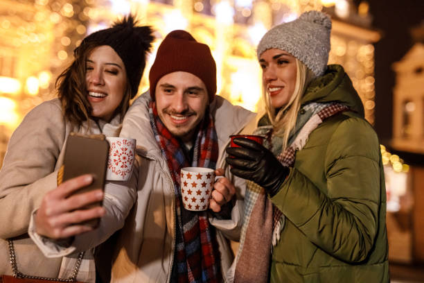 istock Friends taking selfies while enjoying mulled wine in Christmas themed mugs 1683595352