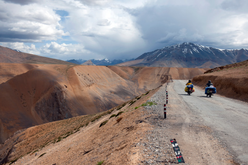 Two men on motorbikes traveling on beautiful tableland Mora, Leh-Manali highway, Ladakh, northern India.