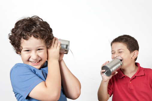 Two kids talking with a tin can phone