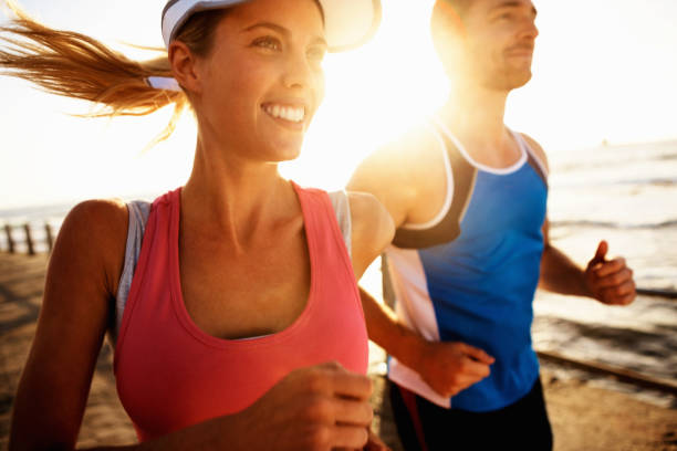 istock Young couple jogging along the beach 168367615