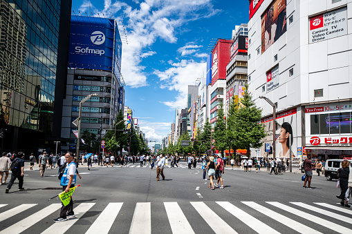 A street scene in Akihabara, Tokyo, Japan on a slightly cloudy day. A bic camera and sofimap store can be seen in the foreground down the street