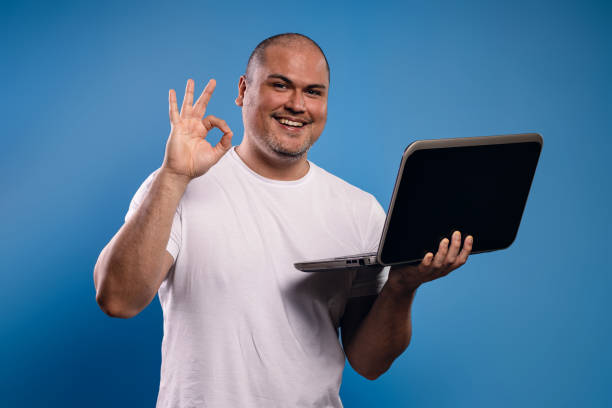 istock man in glasses holding a notebook and making the OK sign 1683684366