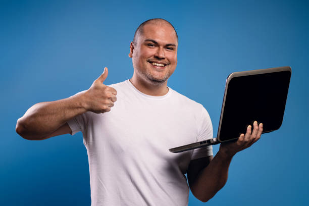 man in glasses holding a notebook and giving a thumbs up