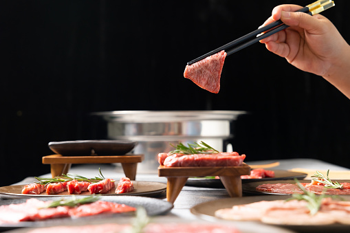 Woman hand using chopsticks pinking up wagyu beef. Grilled japanese premium wagyu beef Sirloin steak